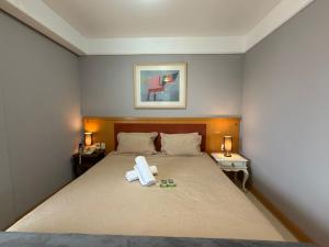 a bedroom with a bed with two towels on it at Hotel Flat Biena Parque Ibirapuera 1101 incluso estacionamento in São Paulo