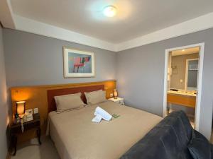 a bedroom with a bed with two towels on it at Hotel Flat Biena Parque Ibirapuera 1101 incluso estacionamento in São Paulo +41 photos