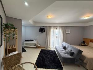 a living room with a couch and a bed at Hotel Flat Biena Parque Ibirapuera 1101 incluso estacionamento in São Paulo