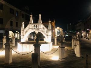 a building with a fountain in the middle of a street at night at Vojko Holidays - Rustika in Koper
