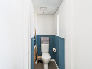 a bathroom with a toilet with a blue wall at Casa Mar in Cortegaça