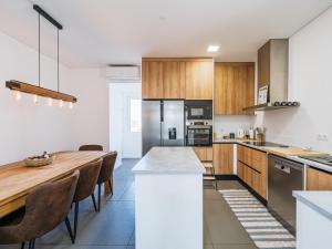 a kitchen with a wooden table and a dining room at Casa Mar in Cortegaça