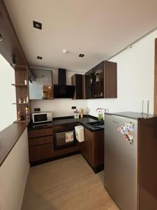 a kitchen with a stainless steel refrigerator and wooden cabinets at Ijou gdena in Sidi Daoud