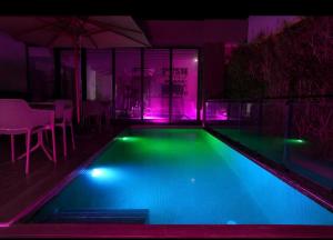 a swimming pool with purple and green lights at Ijou gdena in Sidi Daoud