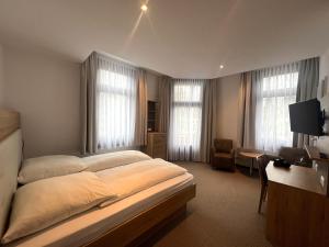 a bedroom with a large bed and a living room at Hotel an der Hauptallee in Bad Pyrmont