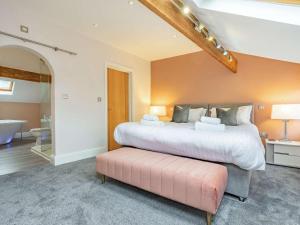 a bedroom with a large bed and a pink ottoman at 2 Bed in Harrogate oc-hh029 in Harrogate