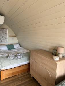a small bedroom with a bed and a wooden cabinet at Handa pod in scottish highlands. in Scourie