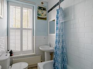 a bathroom with a blue shower curtain and a sink at 4 Bed in Harrogate oc-hh025 in Harrogate +18 photos