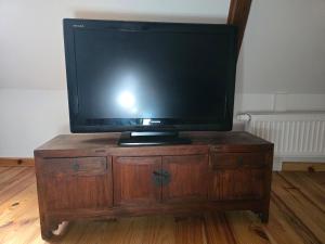 a television sitting on top of a wooden dresser at Apartment in a Chateau with Park in Trébry
