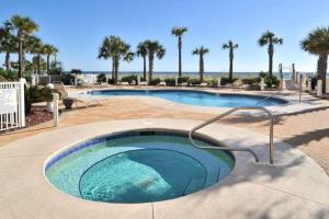 a large swimming pool with palm trees in a resort at Destin Towers 32 in Destin