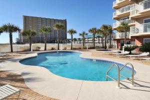 a swimming pool with palm trees and a building at Destin Towers 32 in Destin