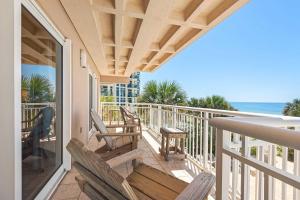 a balcony with chairs and a table and the ocean at Destin Towers 32 in Destin +18 photos