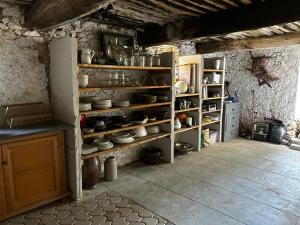 a kitchen with shelves filled with pots and pans at Maison Nomade Provence - MaisonNomadeChic in Coursegoules