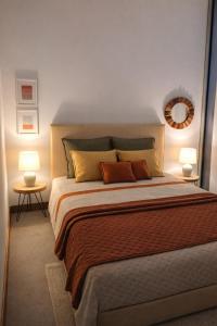a bedroom with a large bed with two lamps at Maré do Bairro Studio Beira Mar Aveiro in Aveiro