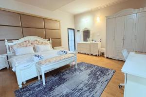 a bedroom with a large white bed and a mirror at Privates Strandhaus auf den Malediven in Kudafari