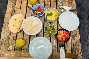 a wooden table topped with plates and bowls of food at Privates Strandhaus auf den Malediven in Kudafari +41 photos