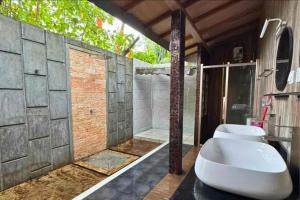 a bathroom with a tub and a toilet and a shower at Privates Strandhaus auf den Malediven in Kudafari