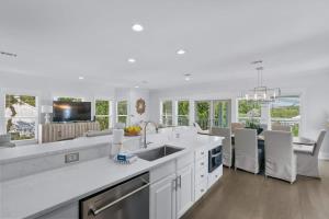 a large white kitchen with white appliances and white cabinets at 80 Blue Sky in Santa Rosa Beach