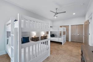 a white room with two bunk beds and a ceiling at 80 Blue Sky in Santa Rosa Beach