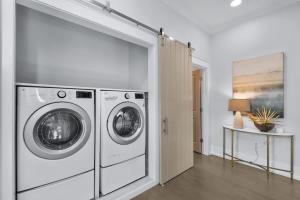 a laundry room with two washing machines and a table at 80 Blue Sky in Santa Rosa Beach