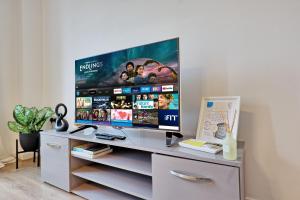 a flat screen tv sitting on top of a cabinet at Spacious 4BR Townhouse, Sleeps 9, Fast WIFI, FREE PARKING, Contractor friendly in Colchester