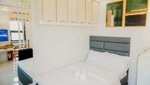 a bedroom with a white bed with a blue headboard at Corner Studio w Wi-Fi CasaMira Labangon in Cebu City
