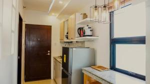 a small kitchen with a refrigerator and a door at Corner Studio w Wi-Fi CasaMira Labangon in Cebu City +4 photos