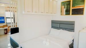 a bedroom with a white bed with a blue headboard at Corner Studio w Wi-Fi CasaMira Labangon in Cebu City