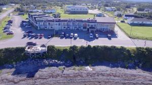 a large building with a lot of cars parked on the side of it at Ocean View Hotel in Rocky Harbour