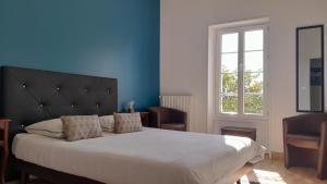 a bedroom with a large bed with a blue wall at Domaine de Pelouaille - chambre d'hôtes in Saint-Jean-dʼAngély