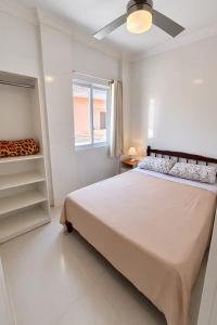 a white bedroom with a large bed and a window at Apartlaguna Prime in Laguna
