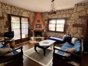 a living room with a stone wall at Stone Villa Rokosini in Vourvourou