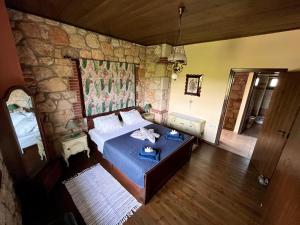 a bedroom with a bed and a stone wall at Stone Villa Rokosini in Vourvourou