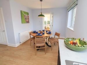 a kitchen and dining room with a table and chairs at Linn Cottage in Hexham
