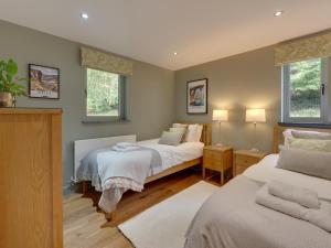 a bedroom with two beds and two windows at 3 Bed in Otley oc-g0176 in Timble