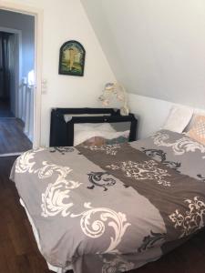 a bedroom with a bed with a brown and white comforter at Woodune in Neufchâtel-Hardelot