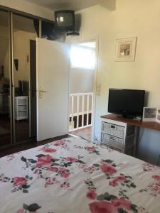 a bedroom with a bed and a television and a door at Woodune in Neufchâtel-Hardelot