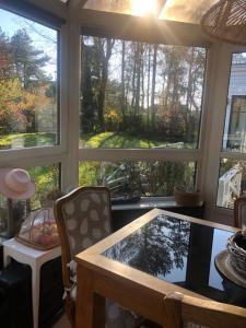 a room with a large window with a table and chairs at Woodune in Neufchâtel-Hardelot