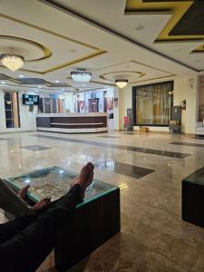 a person sitting in a lobby with their feet in a tub at Narayan resort and restaurant in Aklera