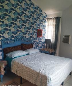 a bedroom with a bed with a blue patterned wall at Privat 3 bedroom apartment in Sosua