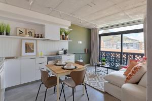 a kitchen and living room with a table and a couch at SIX ON N - Fluent Serviced Apartments in Cape Town