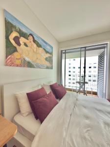 a bedroom with a large white bed with purple pillows at Suíte aconchegante in Lisbon +18 photos