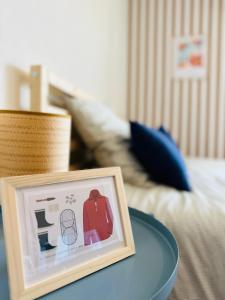 a picture frame on a table next to a bed at Clewis in Saint Malo