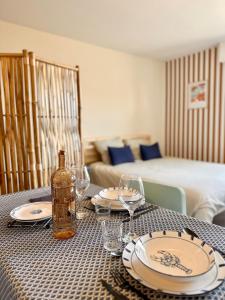 a table with plates and glasses and a bottle on it at Clewis in Saint Malo