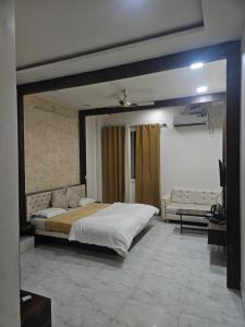 a bedroom with a large bed and a couch at Narayan resort and restaurant in Aklera +2 photos