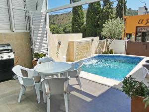 a patio with a table and chairs next to a swimming pool at VILLA MON REPOS CON PISCINA Y A/A in Colera