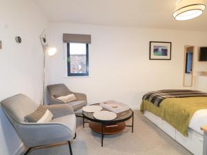 a hotel room with a bed and a couch and chairs at The BullpenManor Farm in Salisbury