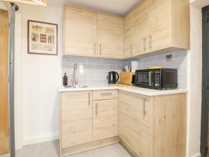 a kitchen with wooden cabinets and a microwave at The BullpenManor Farm in Salisbury +20 photos