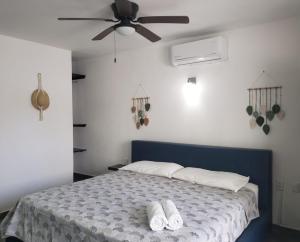a bedroom with a bed with a ceiling fan at Casa Aura in Isla Mujeres