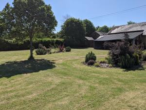 a yard with a tree and a house at The BullpenManor Farm in Salisbury